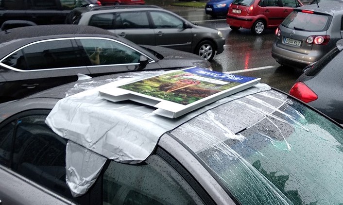 Photo of foto | Șoferii și pietonii când e ploaie se cunosc. Un trecător a acoperit o mașină lăsată cu trapa deschisă și a avut grijă de ea până a venit șoferul