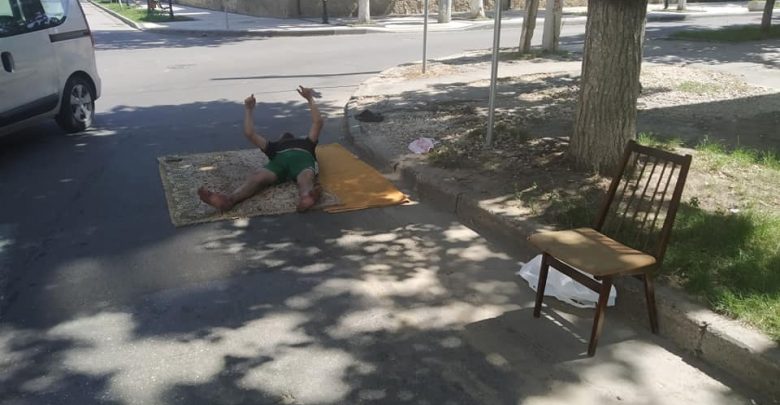 Photo of foto | În loc de plajă – asfaltul din centrul capitalei. Un bărbat și-a așternut un covor și s-a întins chiar pe carosabil