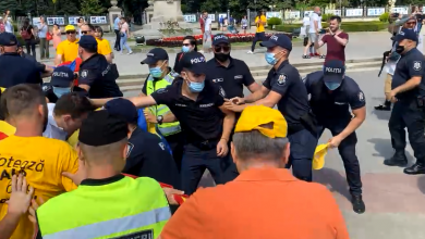 Photo of video | Altercații între unioniști și polițiști: În timpul marșului organizat de socialiști și comuniști, AUR a blocat traseul cu un tricolor imens