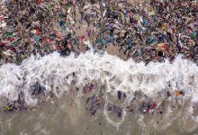 Photo of foto | O plajă din Africa, plină de mormane uriașe de haine. Au format un dig care blochează drumul bărcilor