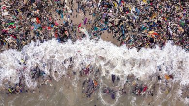 Photo of foto | O plajă din Africa, plină de mormane uriașe de haine. Au format un dig care blochează drumul bărcilor